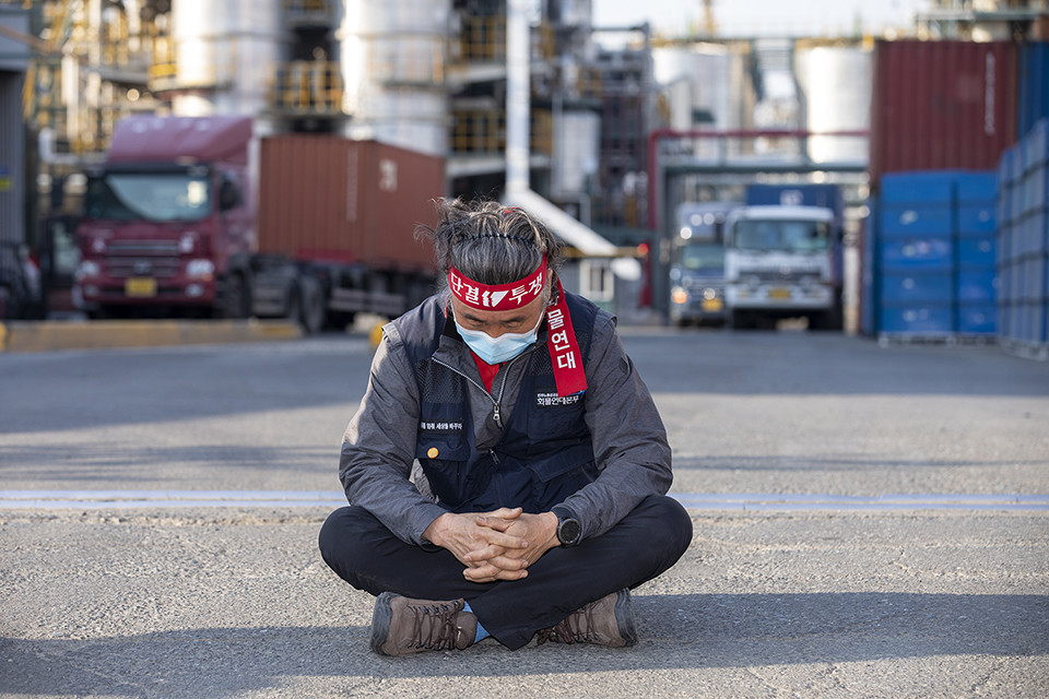 울산지부의 한 조합원이 공장 출입구 앞에 앉아 있다. ⓒ 노동과세계 정종배