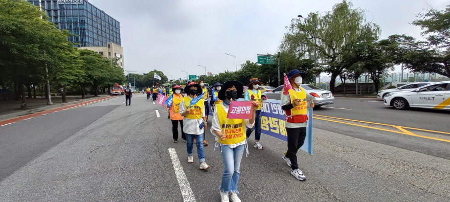 ‘고용안정’과 ‘처우개선’이 써 있는 깃발을 들고 도보행진 하고 있는 한국가스공사 비정규직 노동자들. ⓒ 연정