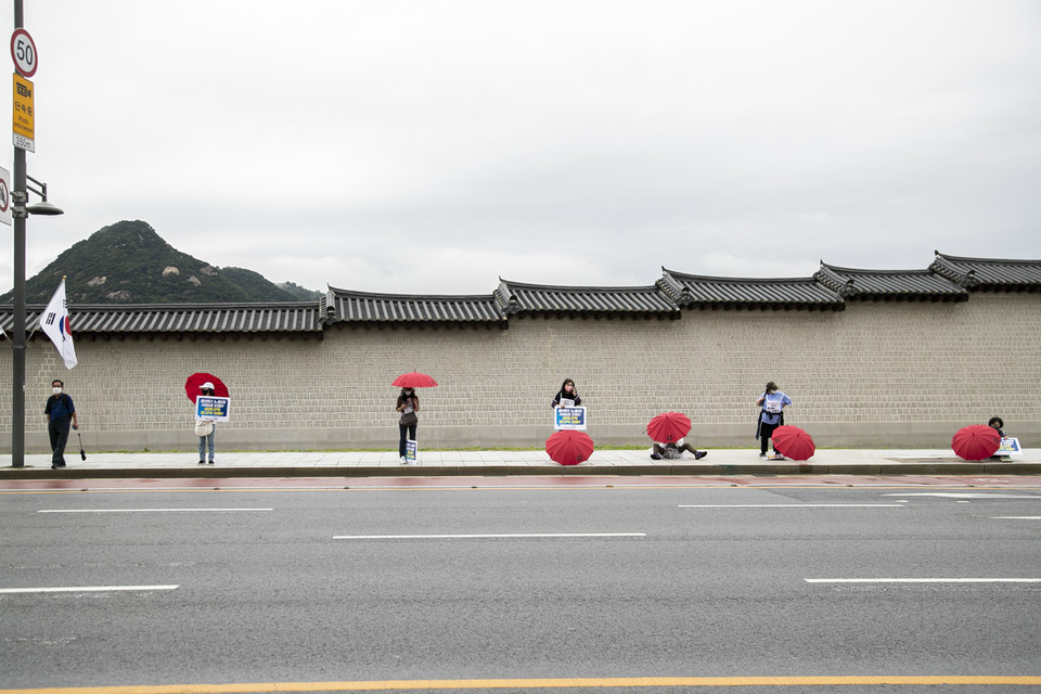 콜센터노동자들이 광화문 앞 대로에서 빨간 우산과 피켓을 들고 임시 선전전을 진행했다. ⓒ 송승현 기자