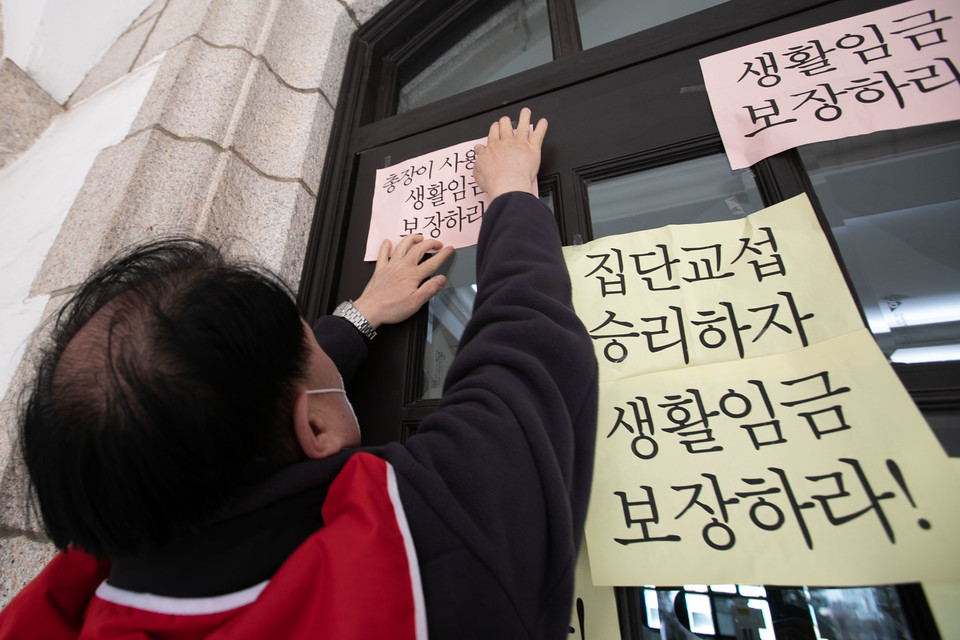   4월 6일 오후 서울 연세대학교 본관 앞에서  공공운수노조 서울지역공공서비스지부 대학 사업장 집단교섭 투쟁 결의대회 참석자가 피켓을 붙이고 있다.   ⓒ 추영욱 기자