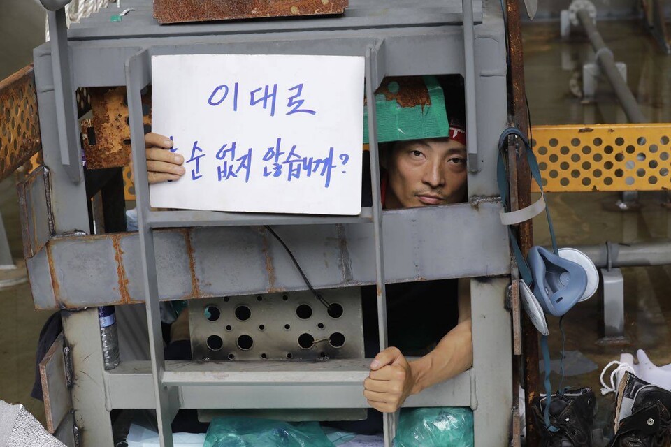 유최안 금속노조 거제통영고성조선하청지회 부지회장이 케이지 안에서 피켓을 들고있다. ⓒ 변백선 기자