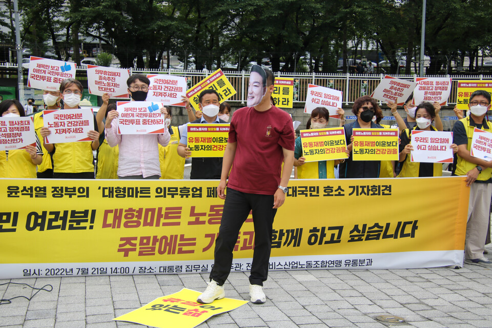 참가자가 '윤석열 대통령이 마트 노동자의 휴식 있는 삶을 짓밟는 모습'을 형상화한 퍼포먼스를 진행하고 있다.