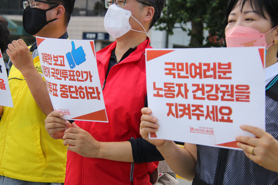 기자회견 참가자들이 국민투표 중단과 노동자 건강권을 지켜달라는 내용의 피켓을 들고 있다.