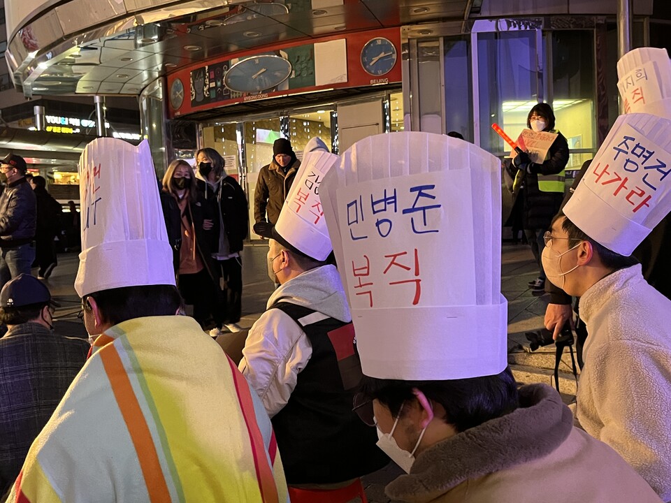  참가자들이 세종호텔 해고자 복직을 요구하는 구호를 적은 모자를 쓰고 있다.