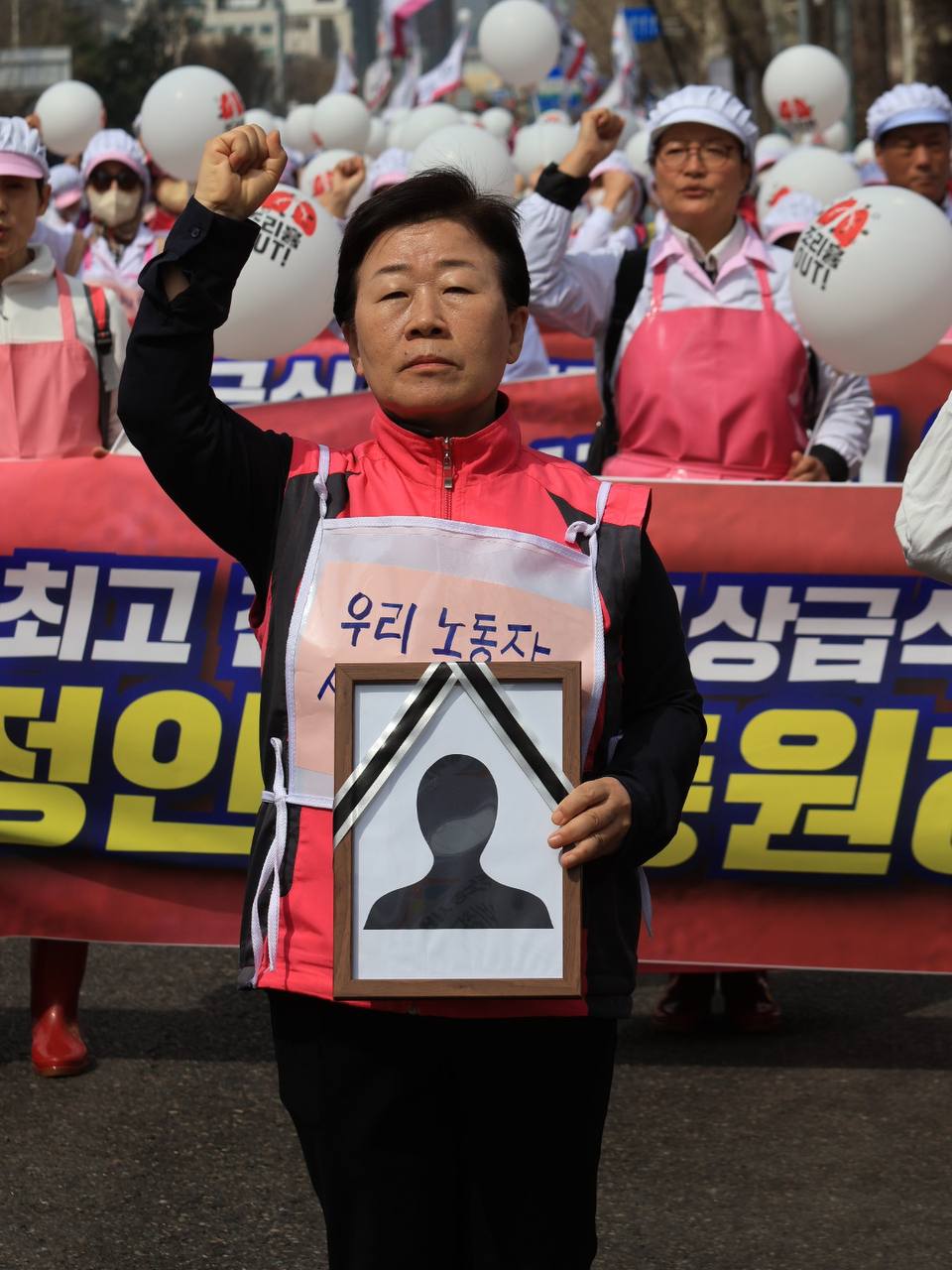 폐암 희생자를 상징하는 영정을 들고 행진하는 학교비정규직노조 박미향 위원장
