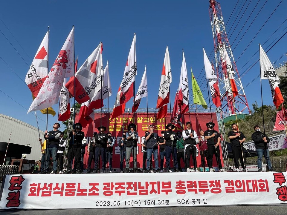 ▲화섬식품노조 광주전남지부 노동자들이 깃발을 들고 포즈를 취하고 있다