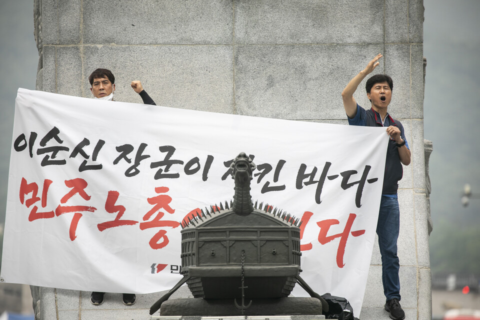 민주노총 조합원들이 12일 오전 10시 서울 종로구 광화문광장 이순신 동상에 올라 일본 핵 오염수 해양투기 방조를 규탄하는 기습시위를 진행했다. ⓒ 송승현 기자
