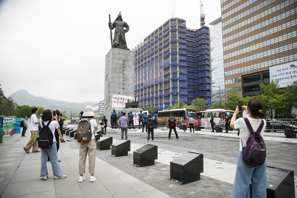 민주노총 조합원들이 12일 오전 10시 서울 종로구 광화문광장 이순신 동상에 올라 일본 핵 오염수 해양투기 방조를 규탄하는 기습시위를 진행했다. ⓒ 송승현 기자
