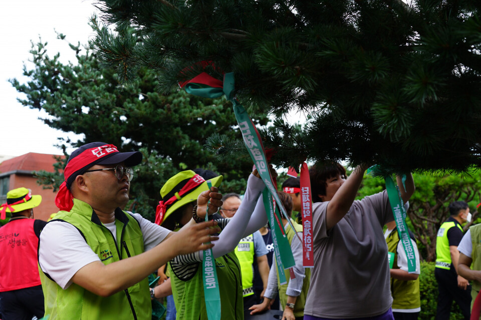 투쟁 승리를 염원하며 나무에 리본을 묶는 참가자들 Ⓒ 보건의료노조