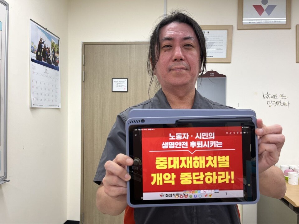 화섬식품노조 조합원이 "중대재해처벌법 개악 중단하라" 손피켓을 들고 있다. 