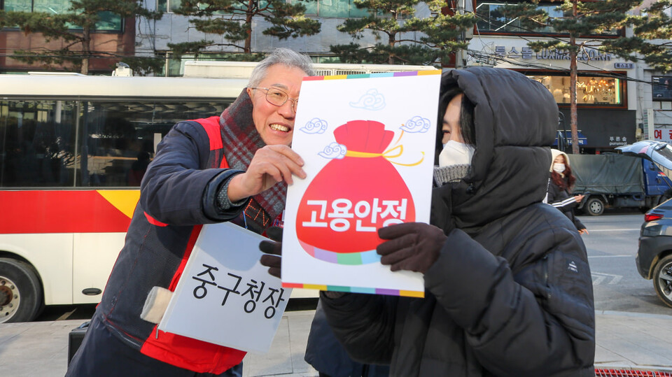 중구청장으로 분한 규탄대회 참가자가 기간제 토론교사들에게 고용안정 복주머니를 나눠주고 있다.