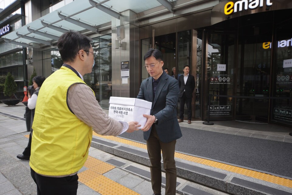 신승훈 이마트지부 위원장이 노조가 진행한 의료비 지원 중단 반대 서명을 사측에 전달하고 있다.