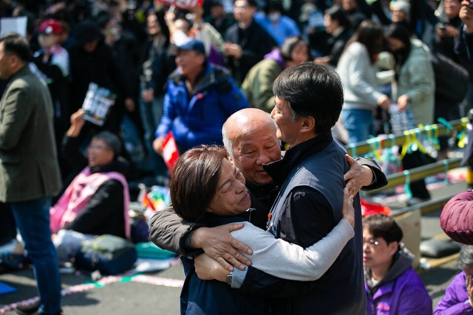 4일 오전 11시 22분 대통령 윤석열이 파면됐다. 파면이 확정된 뒤 서로 기쁨을 나누는 비상행동 공동의장단 양경수 민주노총 위원장과 박석운 전국민중행동 공동대표, 정영이 전여농 회장. 사진=송승현