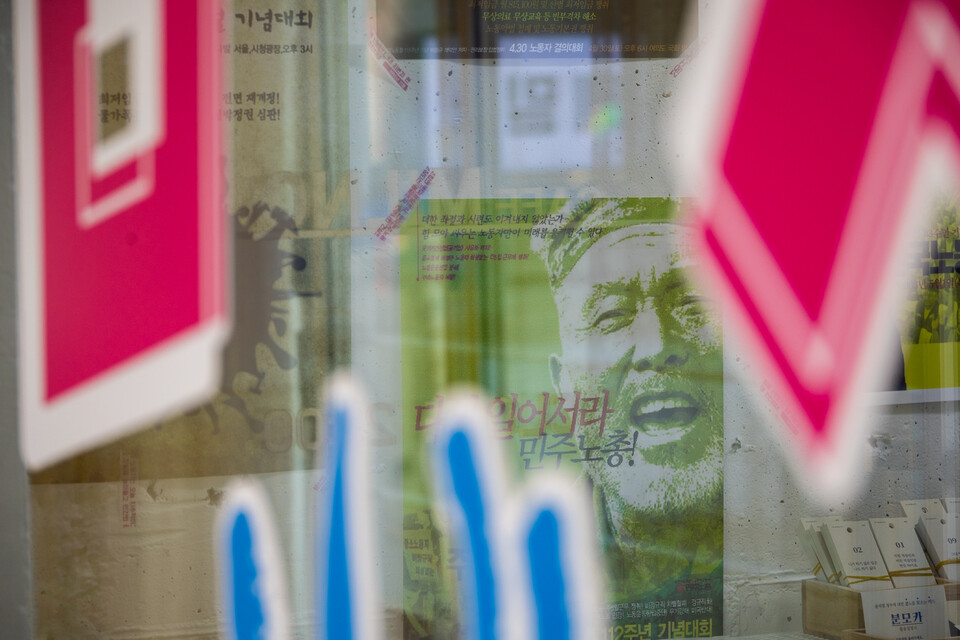 민주노총이 창립 30주년을 맞아 11월 3일부터 25일까지 서울 마포구 연남동에서 해리티지 전시회를 연다. 유리창 너머로 비치는 세계노동절대회 과거 포스터. 사진=송승현