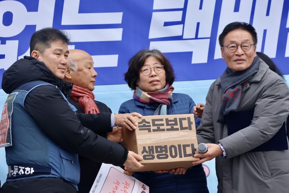 택배노동자들이 시민사회단체 대표들에게 '속도보다 생명이다!'가 적힌 택배를 배송하는 퍼포먼스를 진행했다.  ⓒ서비스연맹